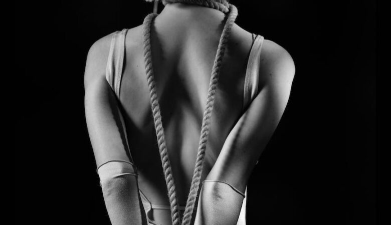 monochrome shot of a person tied with rope